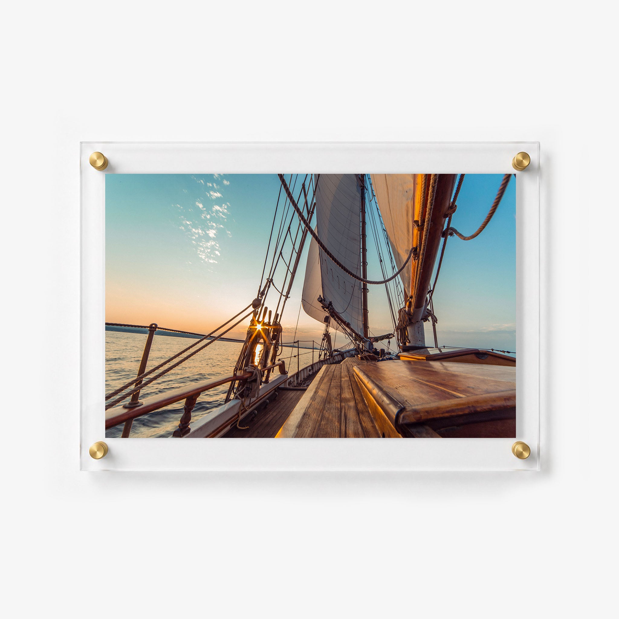 Sunset sailing scene viewed from the deck of a traditional wooden sailboat