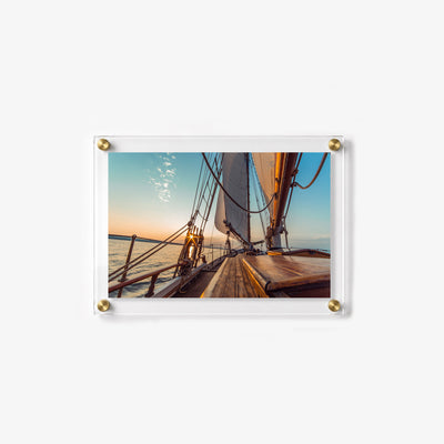Coastal wall art featuring tall sails, rope rigging, and a glowing ocean horizon
