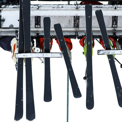 Upward view of ski lift passengers with skis 