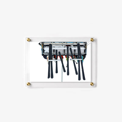 Chairlift scene with skiers, ski poles, and dark skis viewed from below