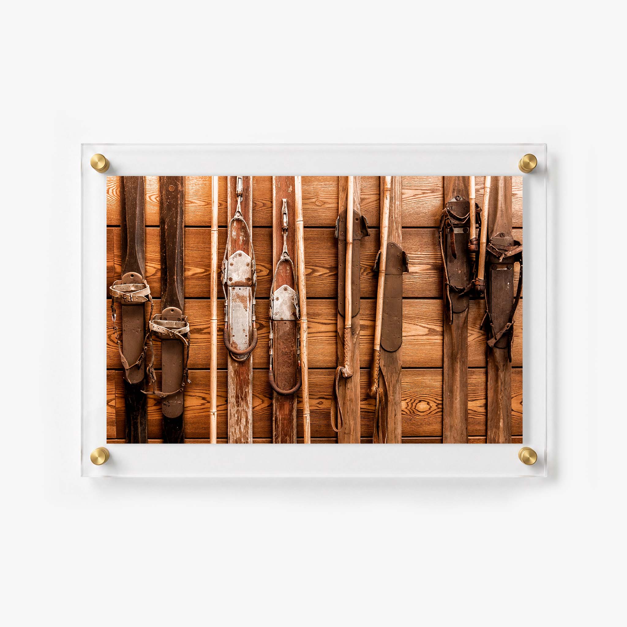 Antique ski collection with leather bindings displayed against a rustic cabin wall