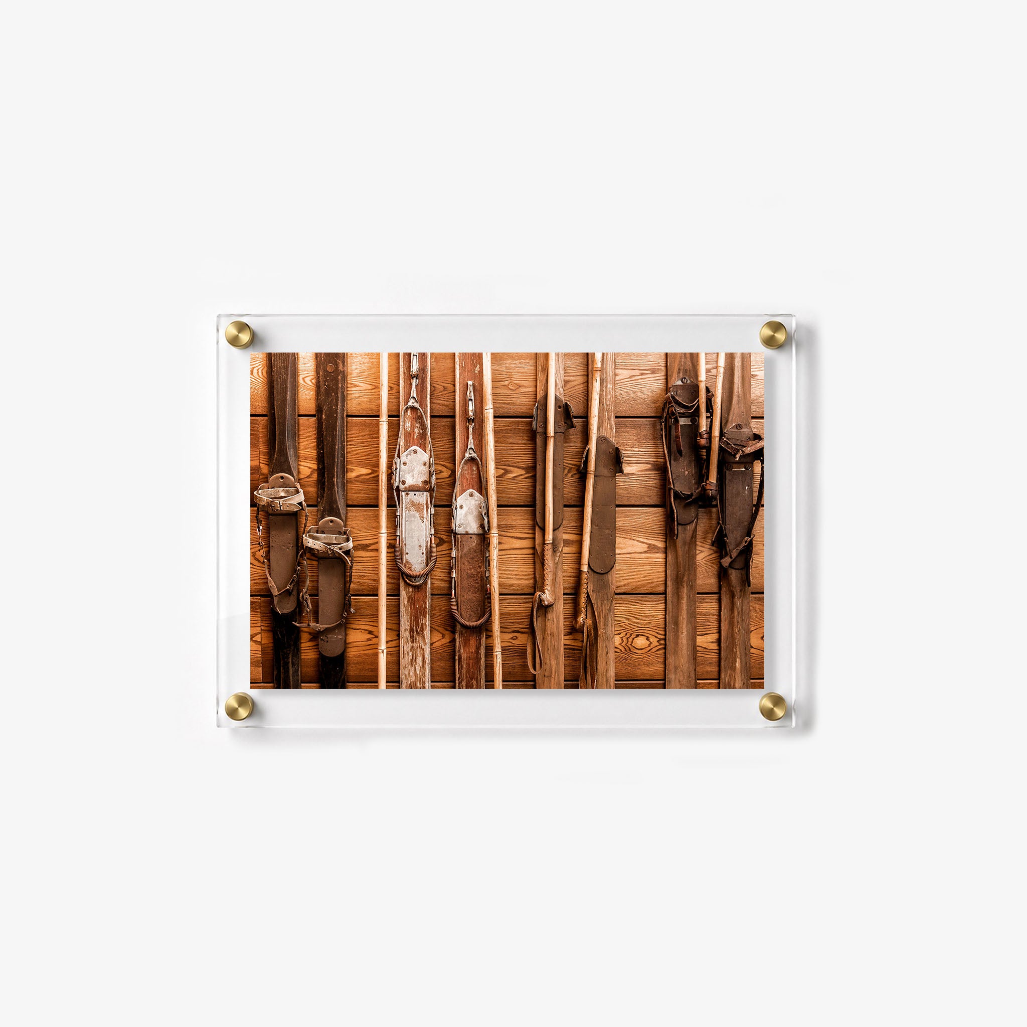 Vintage alpine wall art featuring old skis and ski poles in rich wood tones