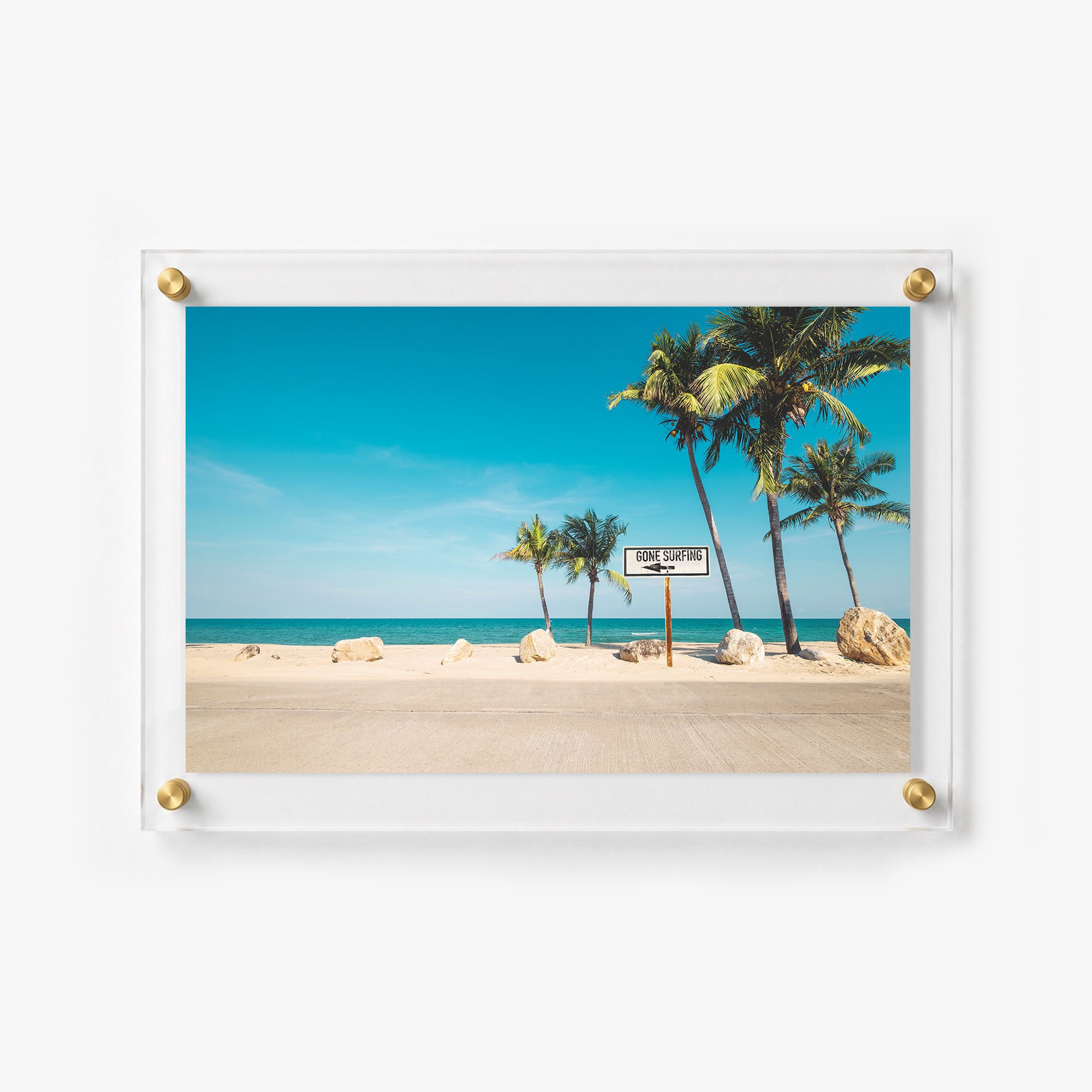 Bright coastal wall art showing a seaside road, palm trees, and a calm blue ocean