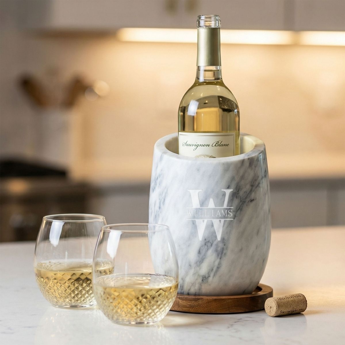 Two avignon glasses with white wine next to a marble wine chiller