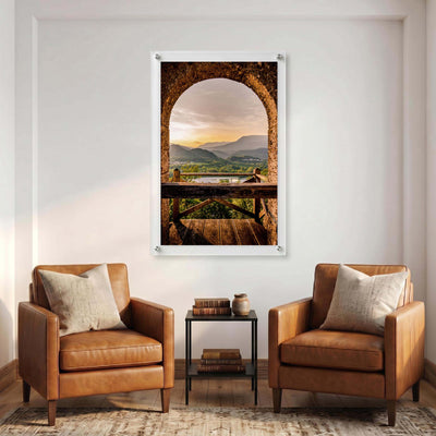 Sunset mountain wall art beneath a weathered stone arch displayed in a room