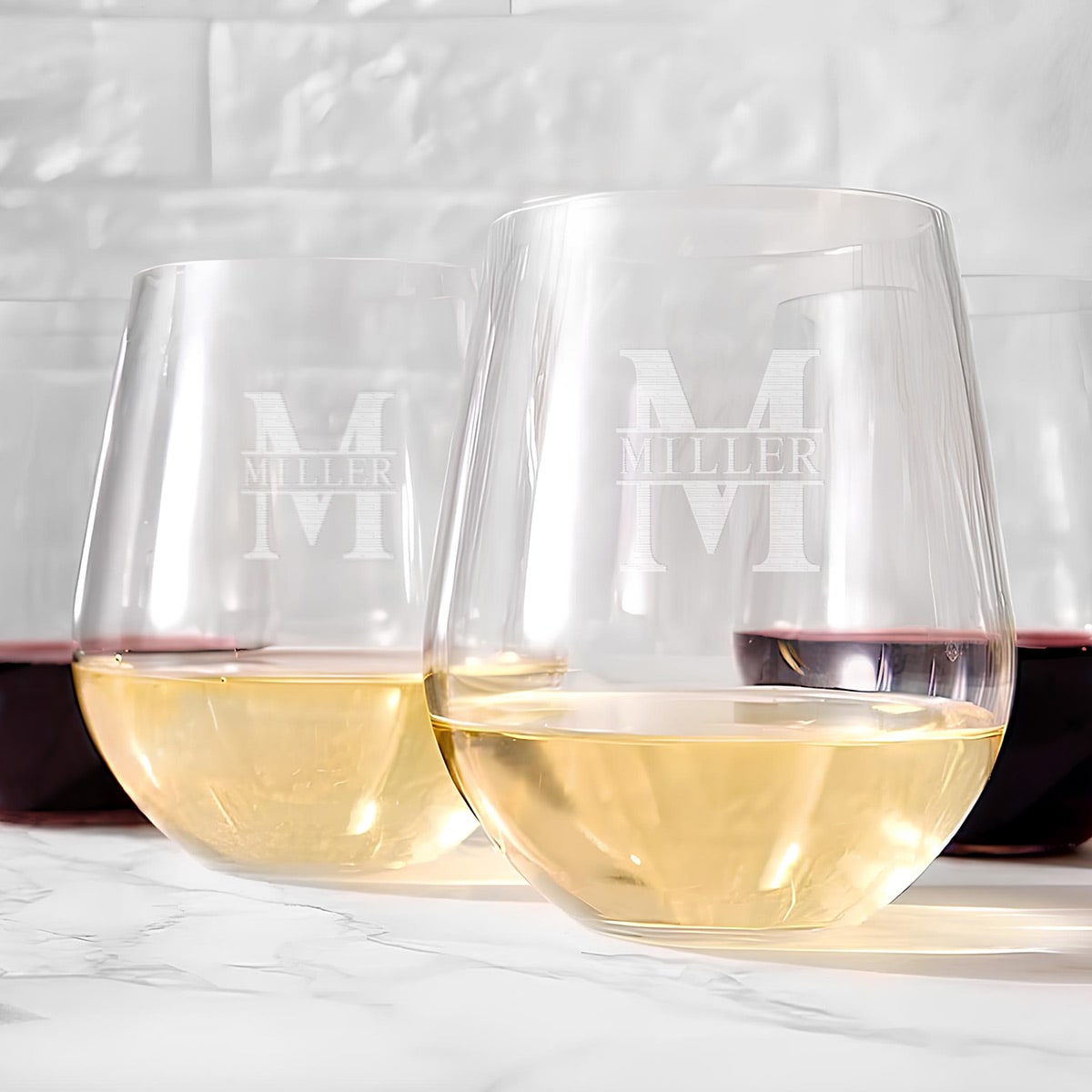 Close-up of two Tritan stemless wine glasses with matching engraved name and initial.