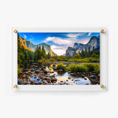 Mountain landscape featuring a rocky river surrounded by trees and dramatic granite cliffs