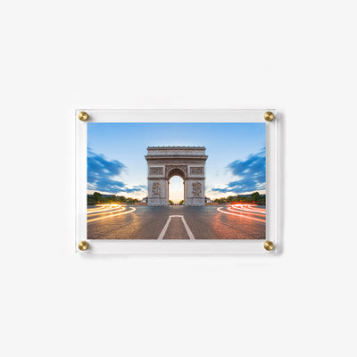 Long exposure city scene featuring the Arc de Triomphe and illuminated traffic at dusk