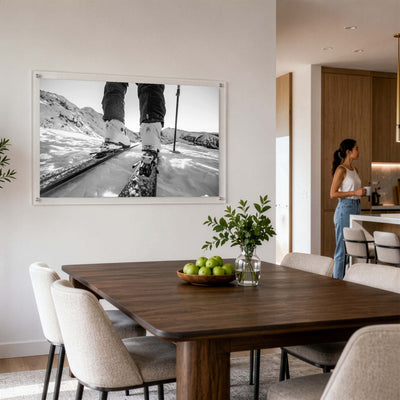 Black and white mountain road wall art in a modern dining room with a woman standing