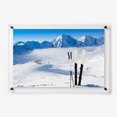 Skis and poles standing in the snow above a wide alpine ski resort