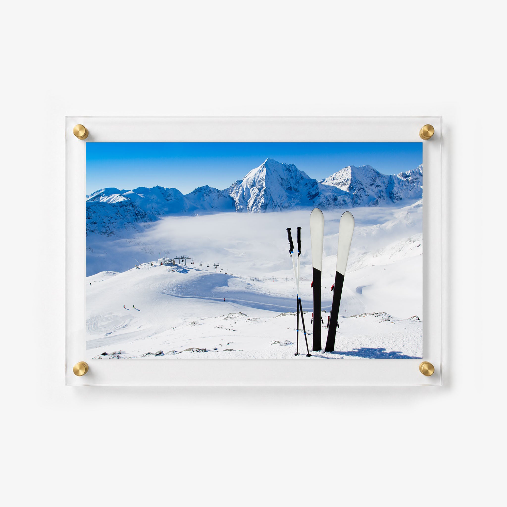 Scenic ski slope photograph with upright skis, chairlifts, and snow covered peaks