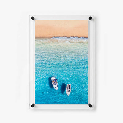 Overhead ocean scene featuring two white boats floating above crystal clear water