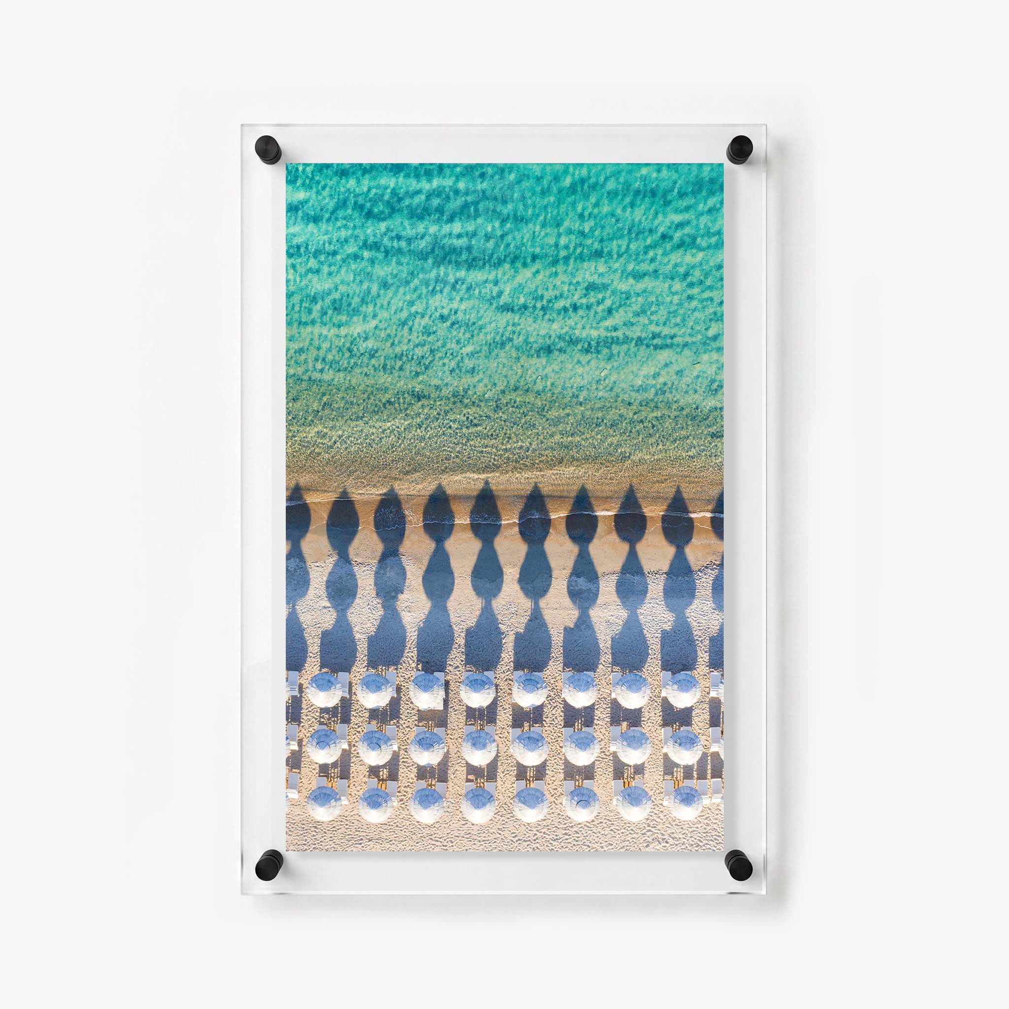 Overhead beach scene with white umbrellas, lounge chairs, golden sand, and gentle waves