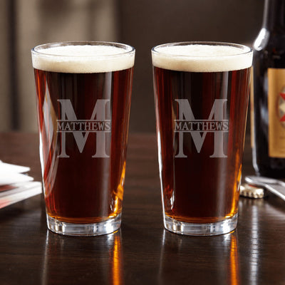 Two etched beer glasses with 'MATTHEWS' branding on a wooden surface.