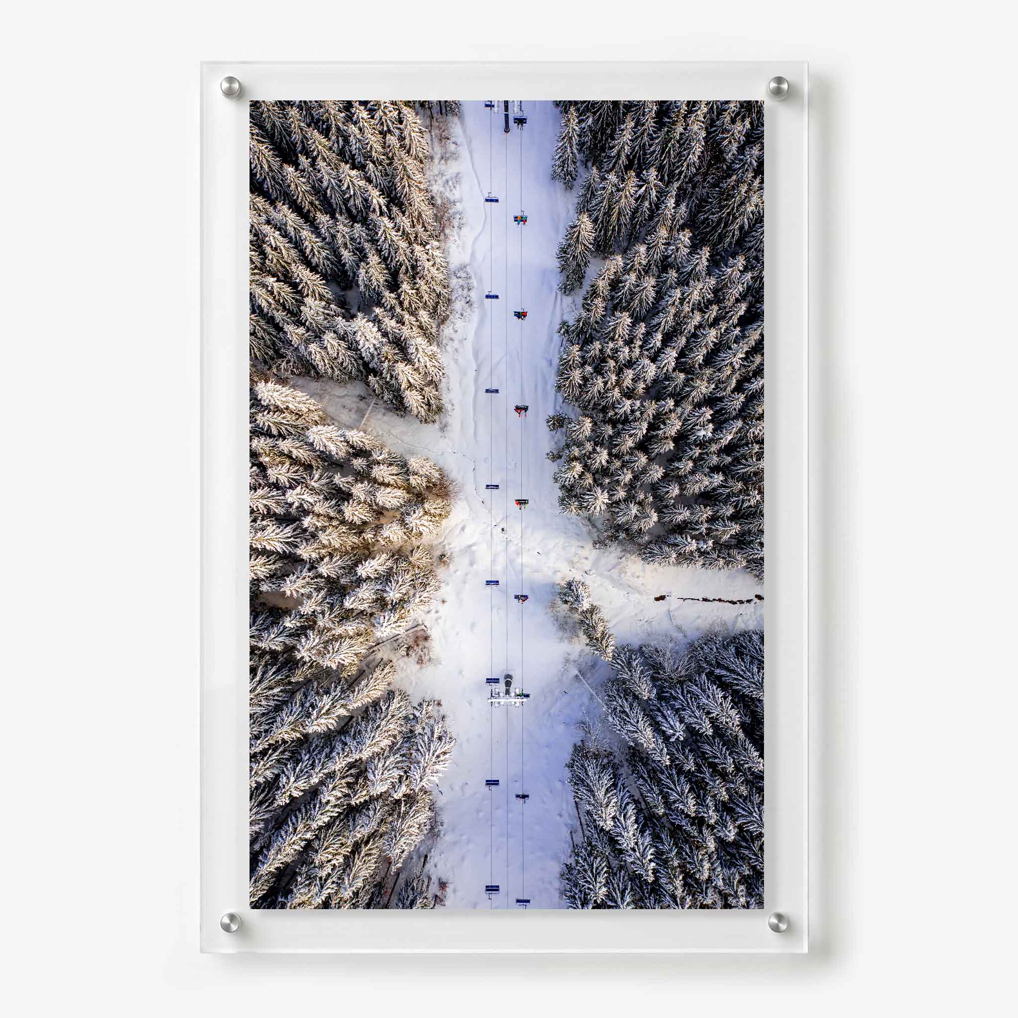 Acrylic wall art featuring an aerial view of a ski lift crossing a snow covered evergreen forest