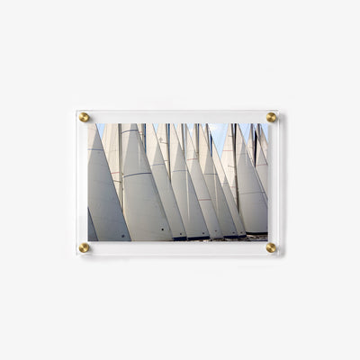 Close view of multiple sailboat sails lined up together at the harbor
