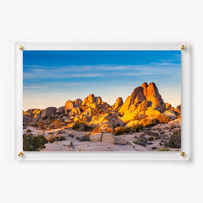 Acrylic wall art featuring sunlit desert boulders beneath a clear blue sky