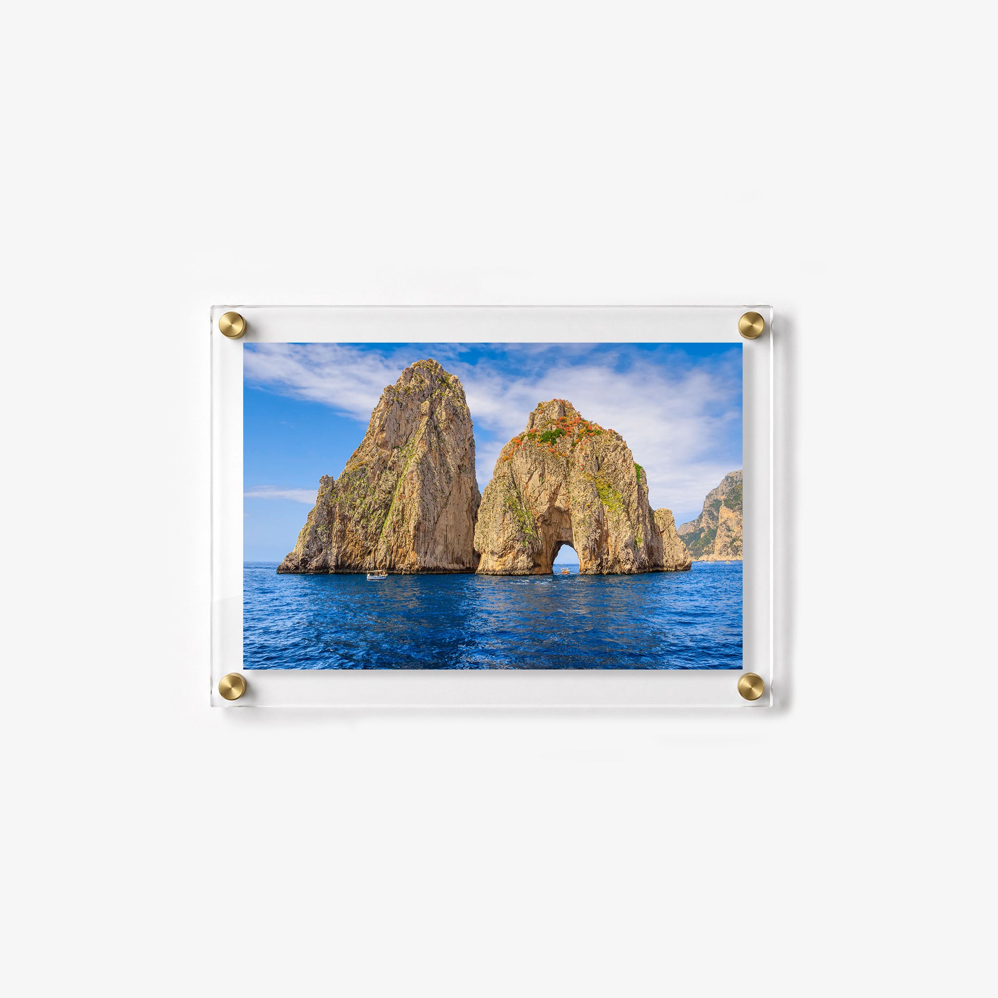 Horizontal acrylic print featuring rocky sea stacks, small boats, and vivid blue ocean water