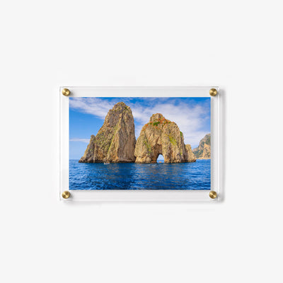 Horizontal acrylic print featuring rocky sea stacks, small boats, and vivid blue ocean water