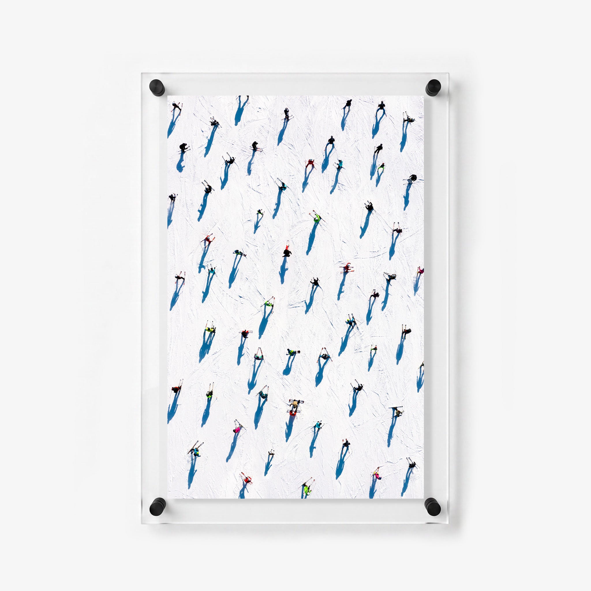 Colorful skiers scattered across a white ski trail in a vertical acrylic wall print