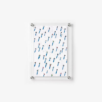 Vertical winter wall print showing small skiers and vivid blue shadows across a white ski field