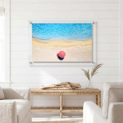 Acrylic wall art showing a lone beach umbrella displayed in a bright living room