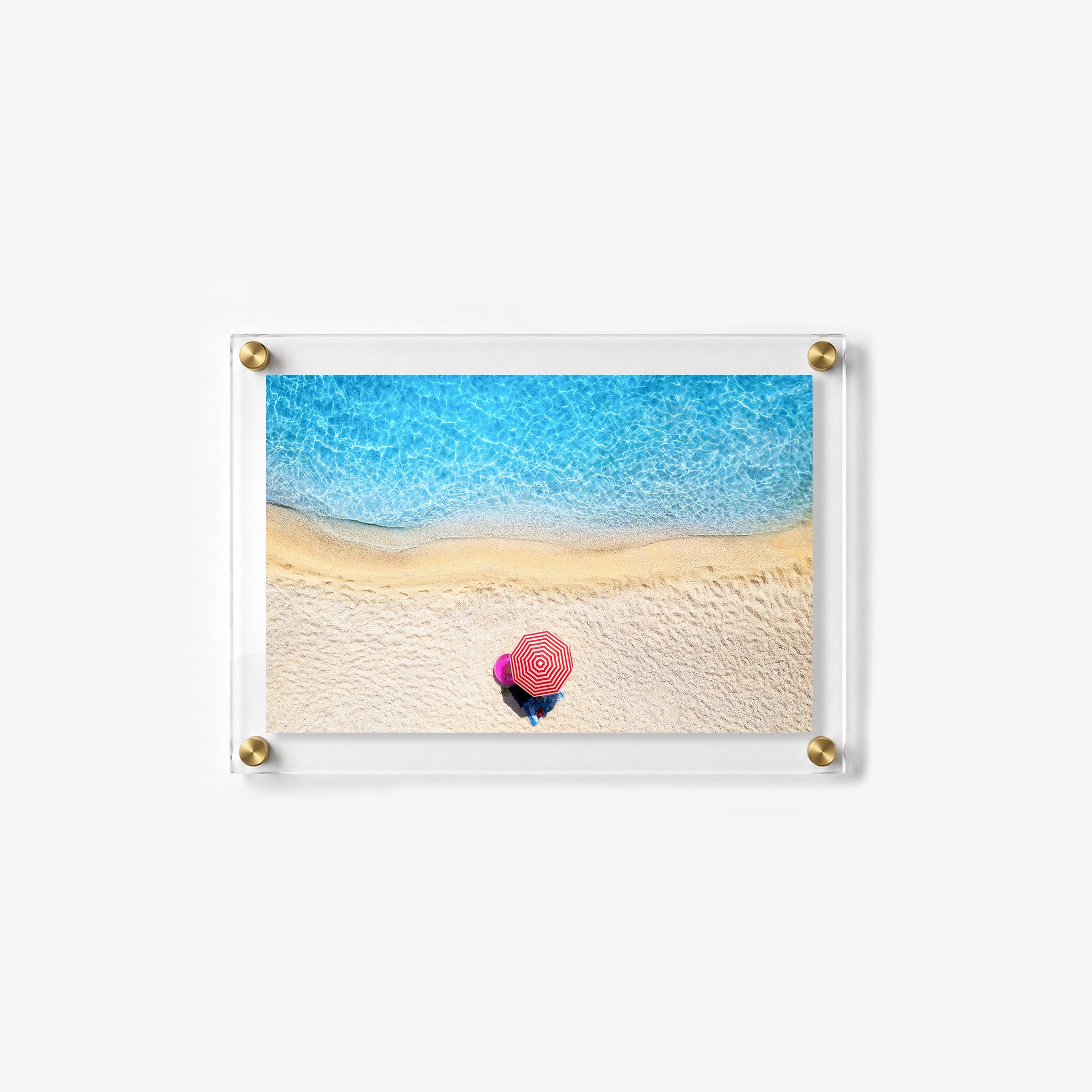 Minimal beach scene with a single striped umbrella 