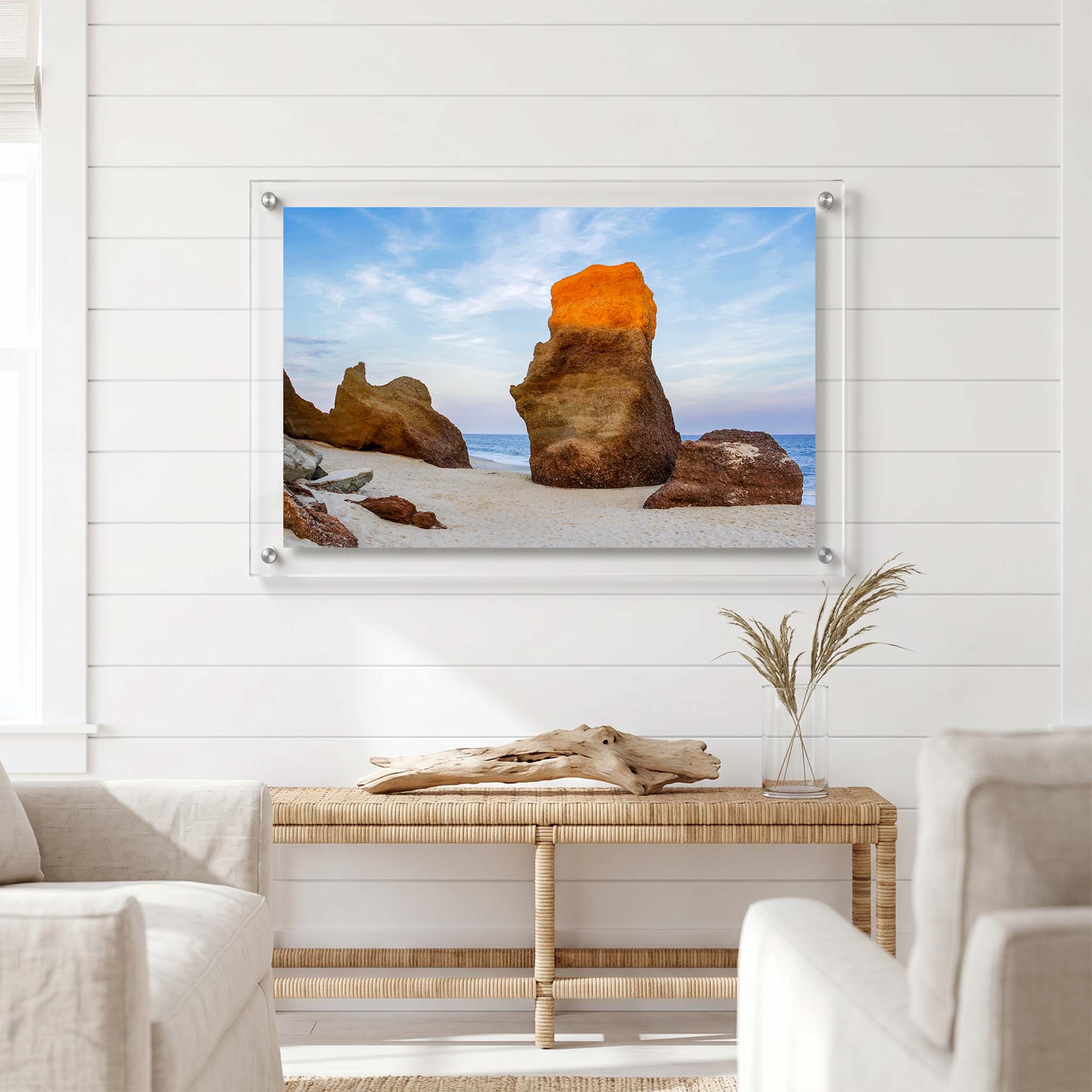 Beach wall art showing rugged stone formations displayed in a bright room