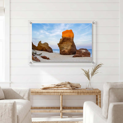 Beach wall art showing rugged stone formations displayed in a bright room
