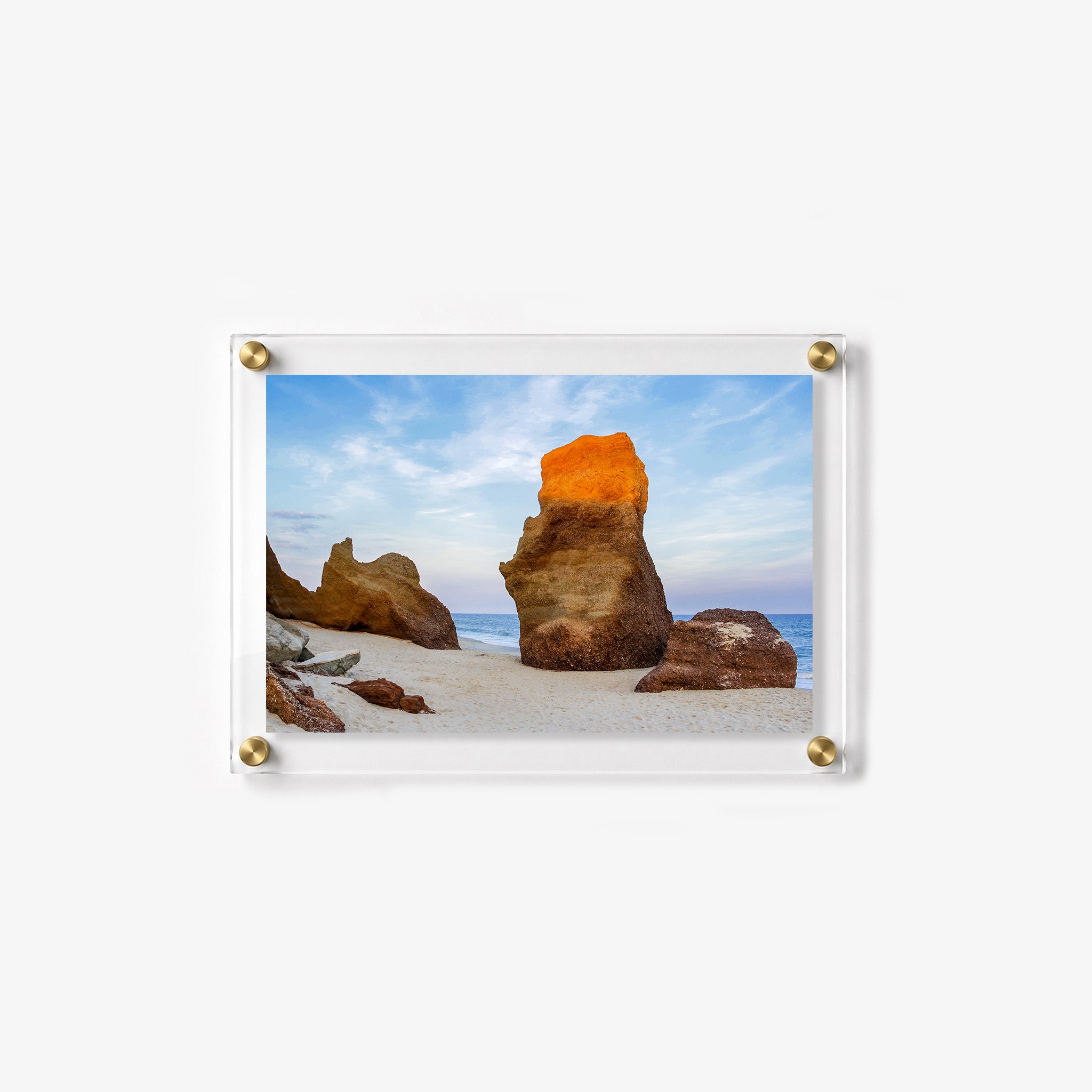 Large weathered rock formation standing on a quiet beach 