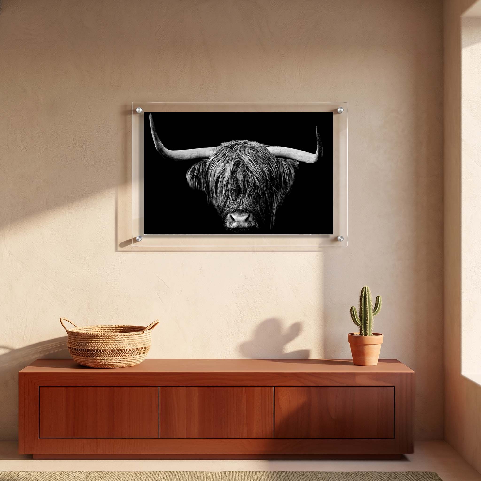 Monochrome wall art showing a long horned Highland cow displayed in an entryway