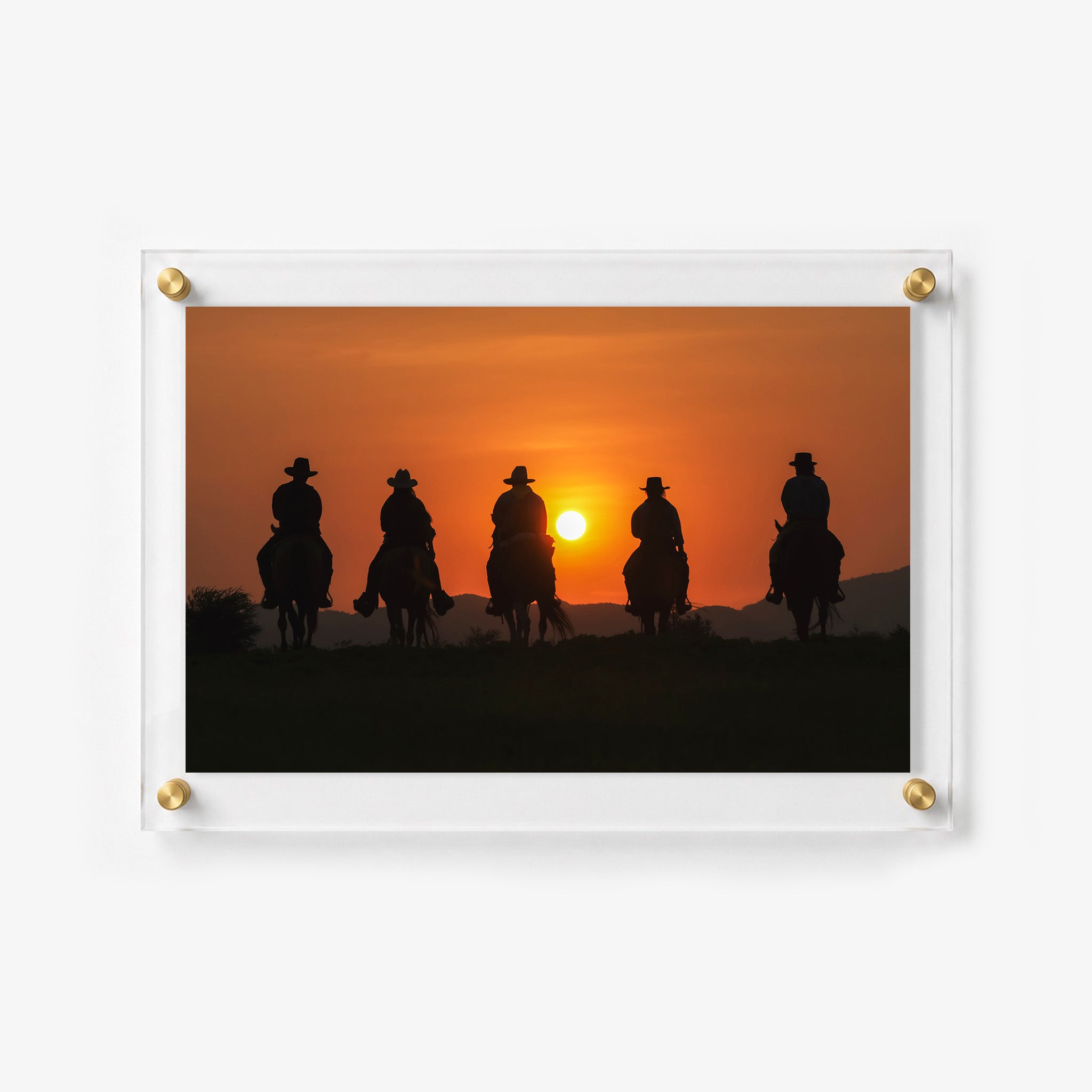 Dramatic western scene featuring mounted riders at sunset