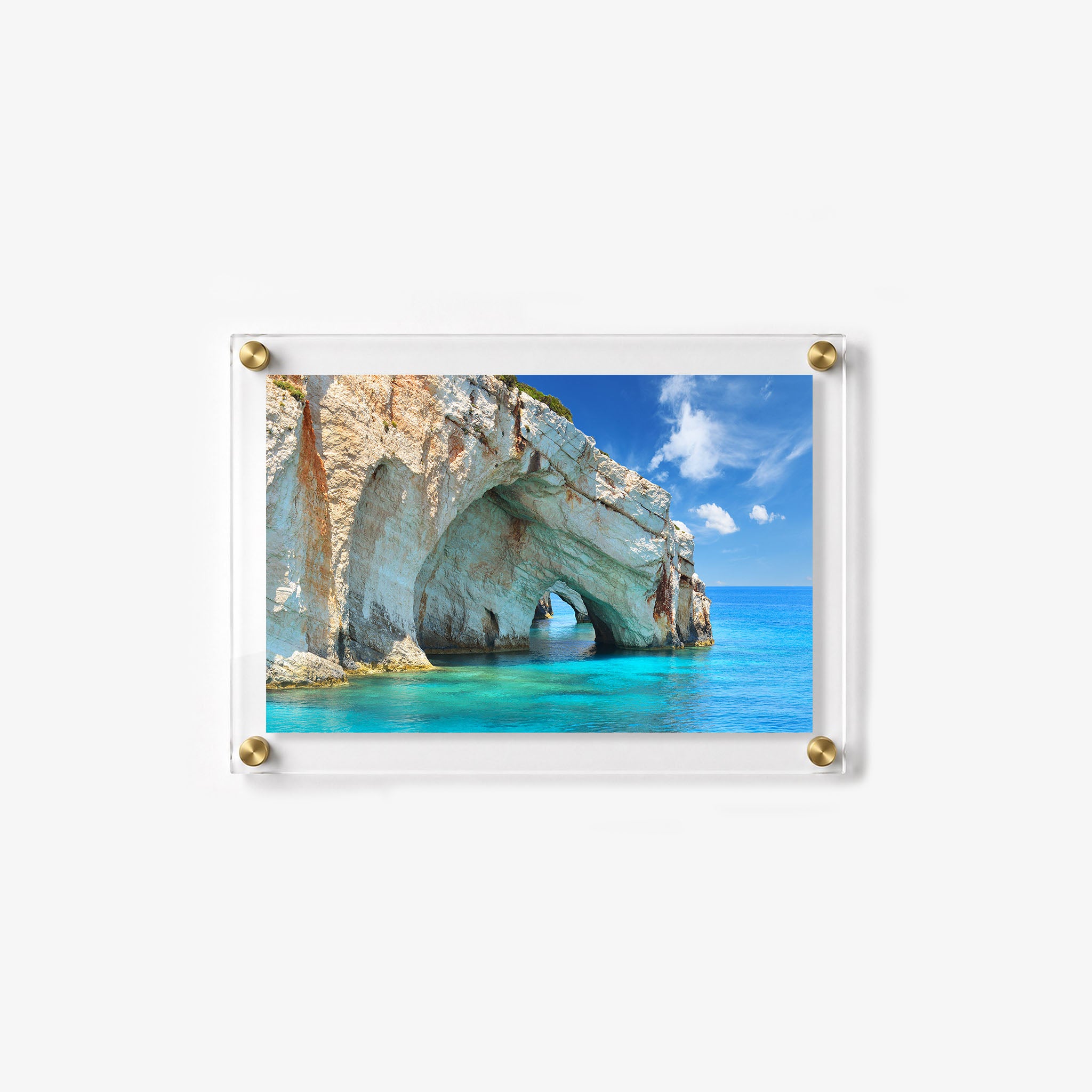Sunlit ocean cliff with a dramatic natural arch and calm crystal clear sea