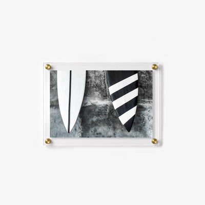 Close up wall art showing the pointed ends of two surfboards with contrasting striped patterns