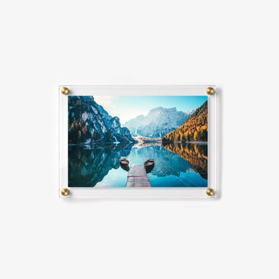Peaceful alpine landscape with a dock, two wooden boats, and dramatic mountain reflections