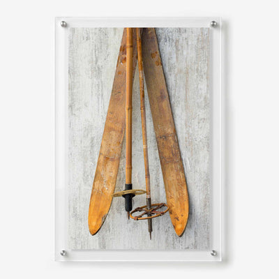 Acrylic wall art featuring vintage wooden skis and bamboo ski poles