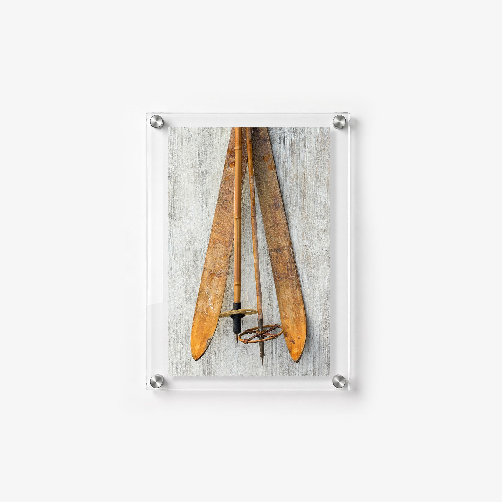 Antique skis and bamboo poles displayed against a distressed wood backdrop