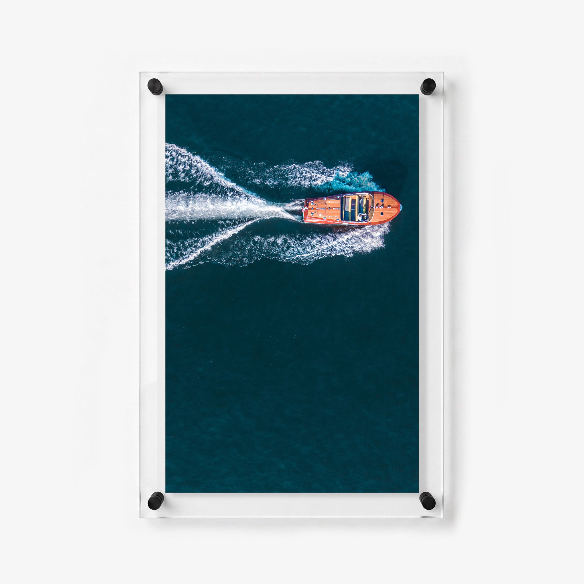 Wooden powerboat leaves a bright foamy trail behind it in calm blue water